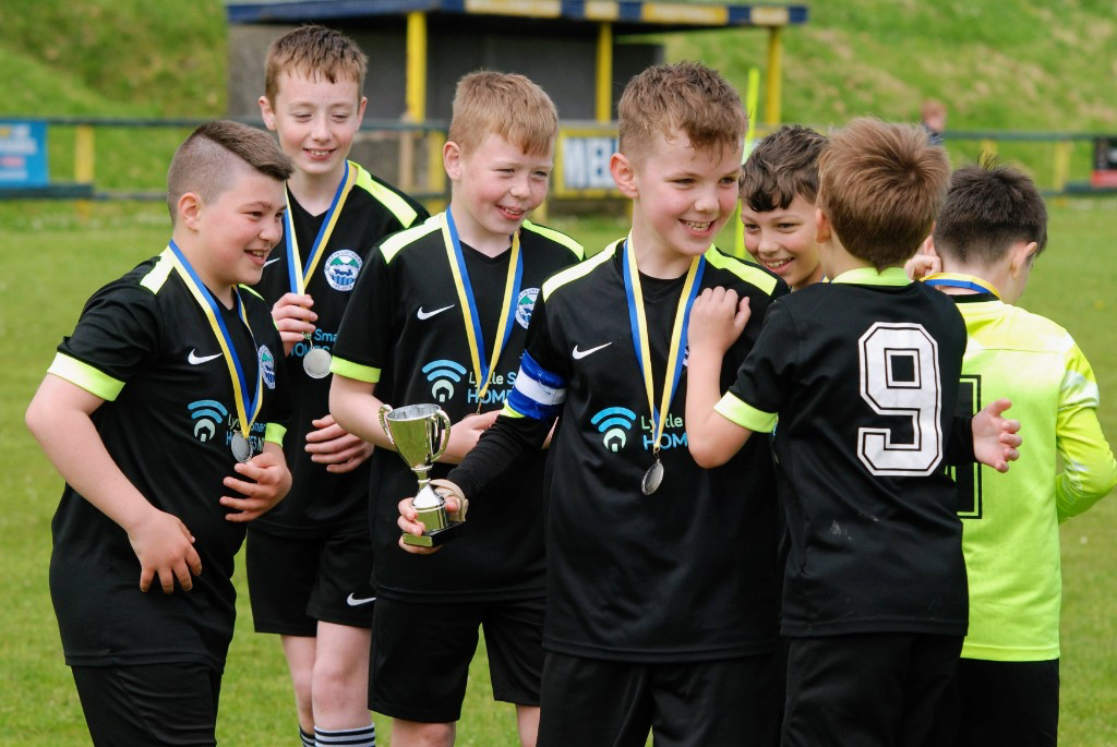 Glens United squad celebrating with trophies