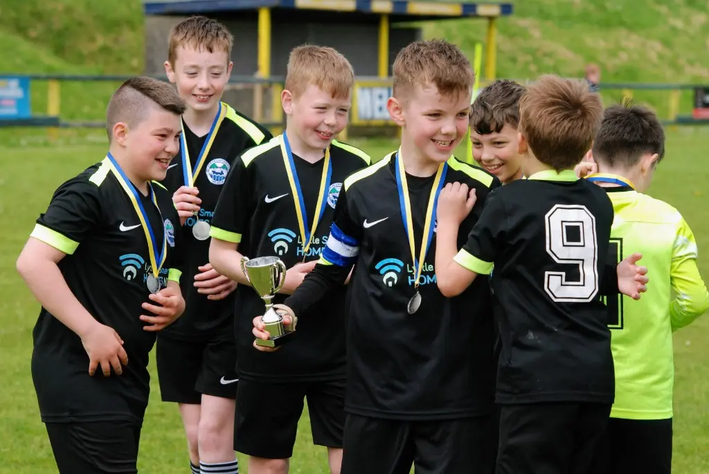 Glens United squad celebrating with trophies